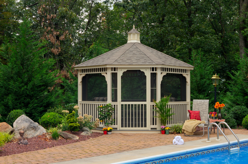 Example of a large classic backyard brick patio design in New York with a gazebo