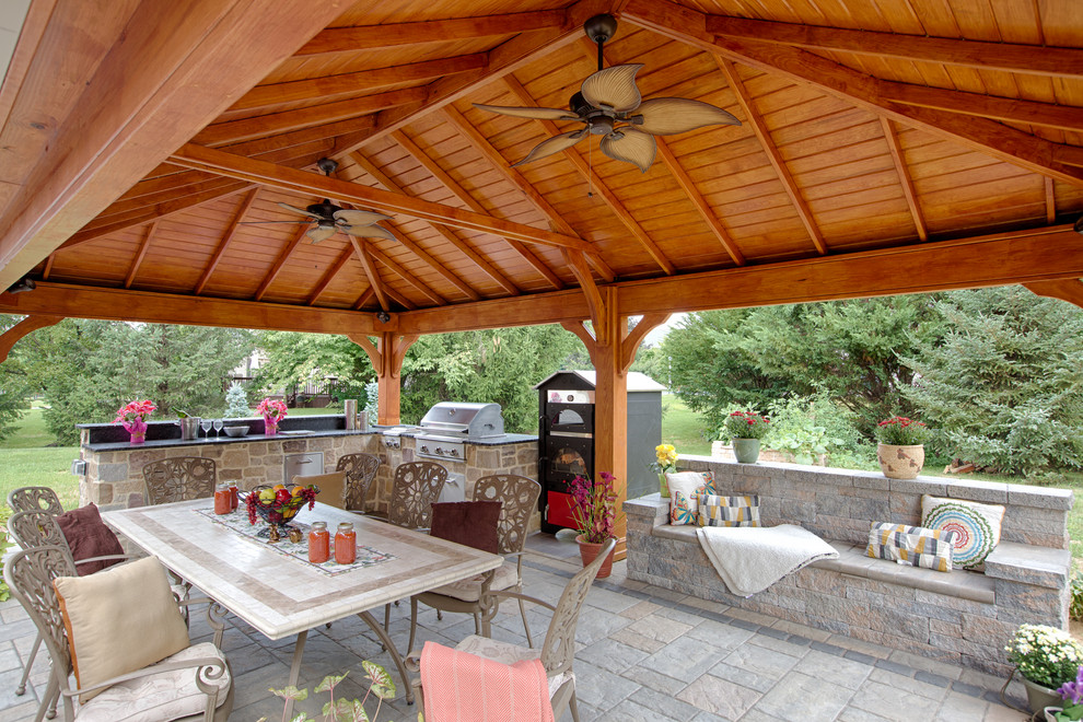 Ejemplo de patio clásico renovado grande en patio trasero con cocina exterior, adoquines de hormigón y cenador