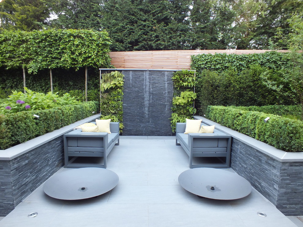 This is an example of a medium sized contemporary patio in Hertfordshire with a living wall and no cover.
