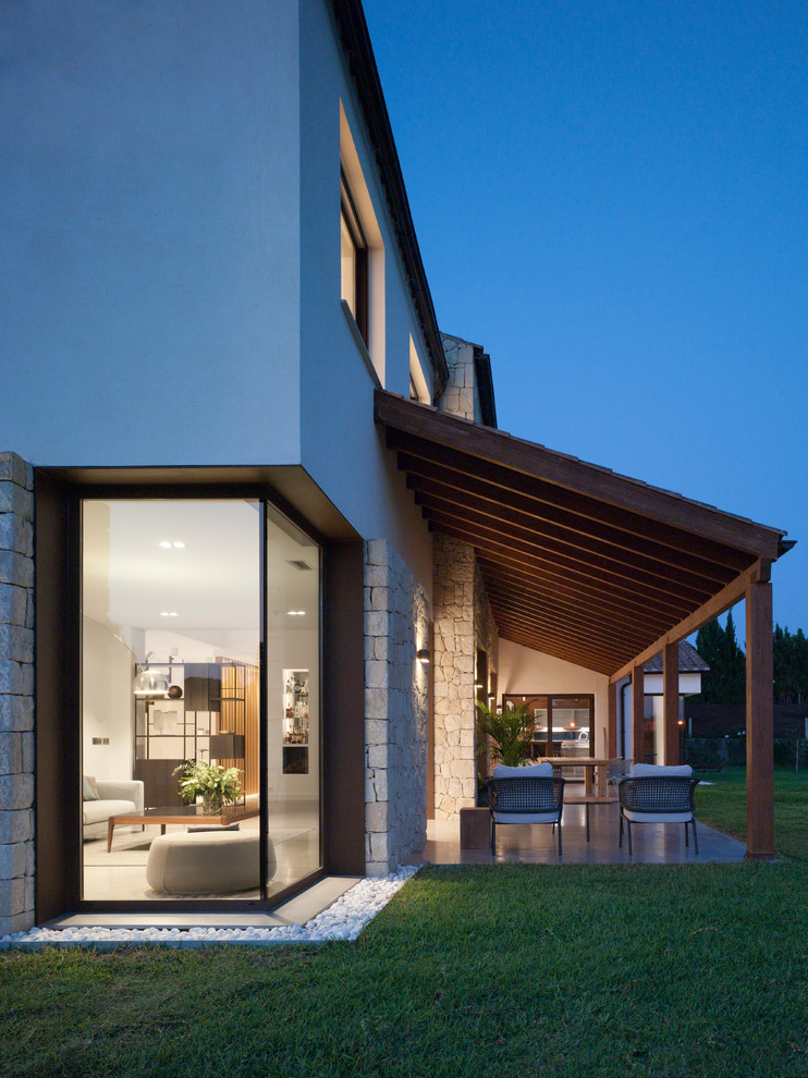Esempio di un patio o portico minimal dietro casa con lastre di cemento e una pergola