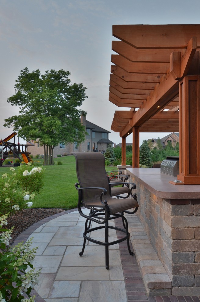 Idées déco pour une terrasse arrière classique de taille moyenne avec une cuisine d'été, des pavés en béton et une pergola.
