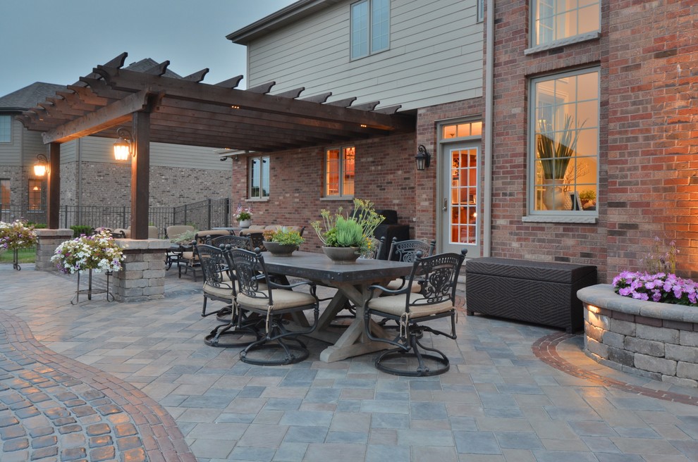 Design ideas for a large bohemian back patio in Chicago with a fire feature, concrete paving and a pergola.