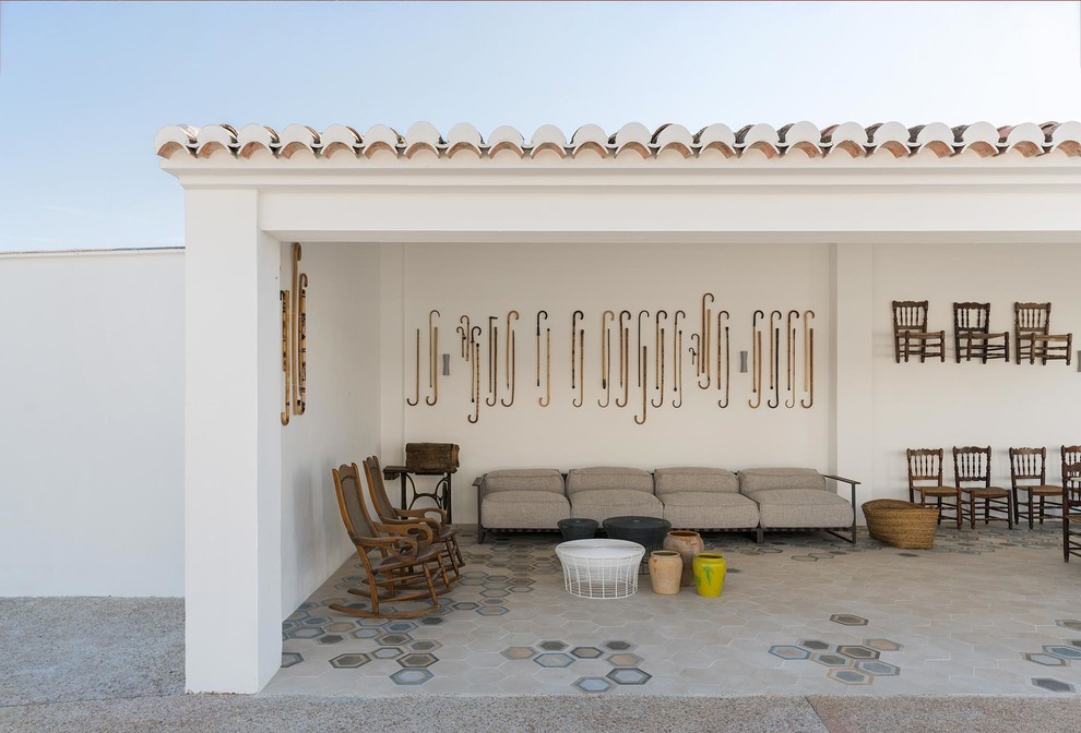 Diseño de patio mediterráneo en anexo de casas con suelo de baldosas