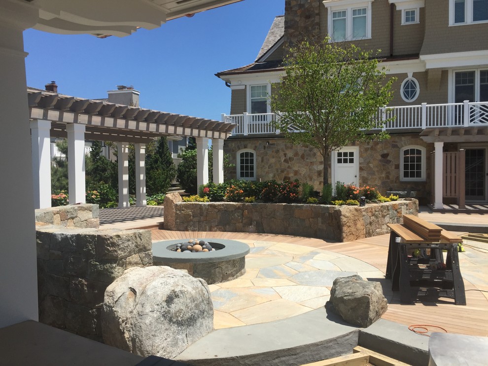Inspiration for a traditional back patio in New York with natural stone paving.