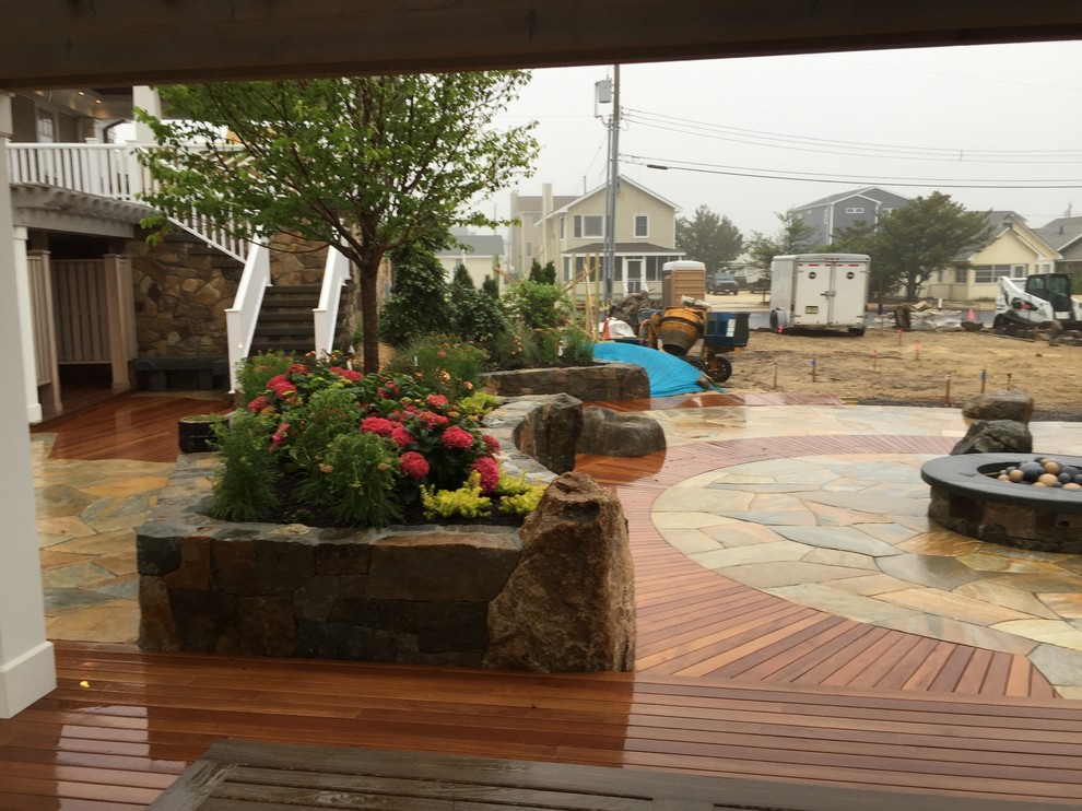 Foto di un patio o portico eclettico dietro casa con un focolare e pavimentazioni in pietra naturale