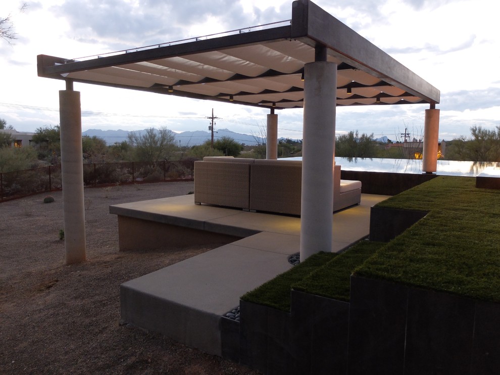 Cette image montre une grande terrasse arrière design avec un foyer extérieur, des pavés en béton et un gazebo ou pavillon.