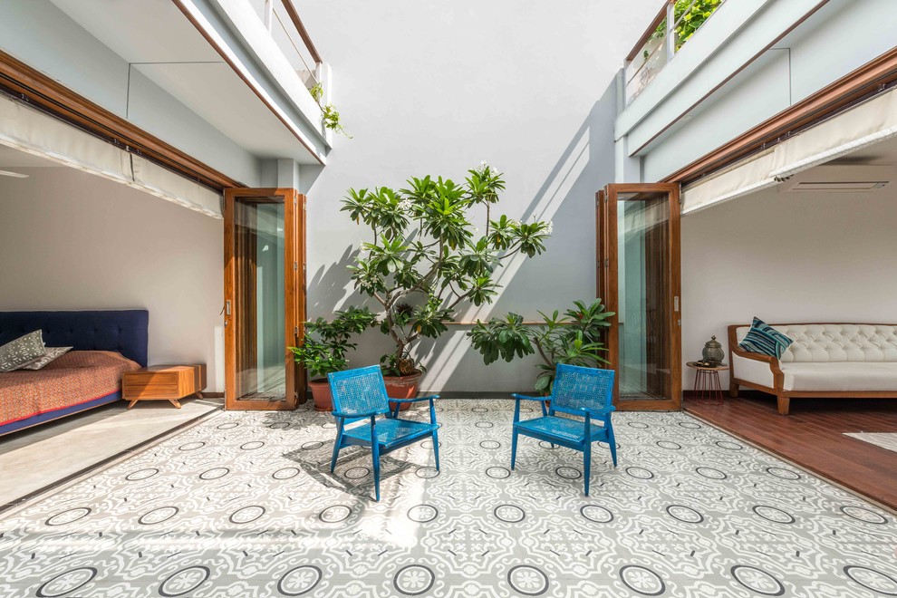 Example of a large zen courtyard tile patio design in Delhi with no cover