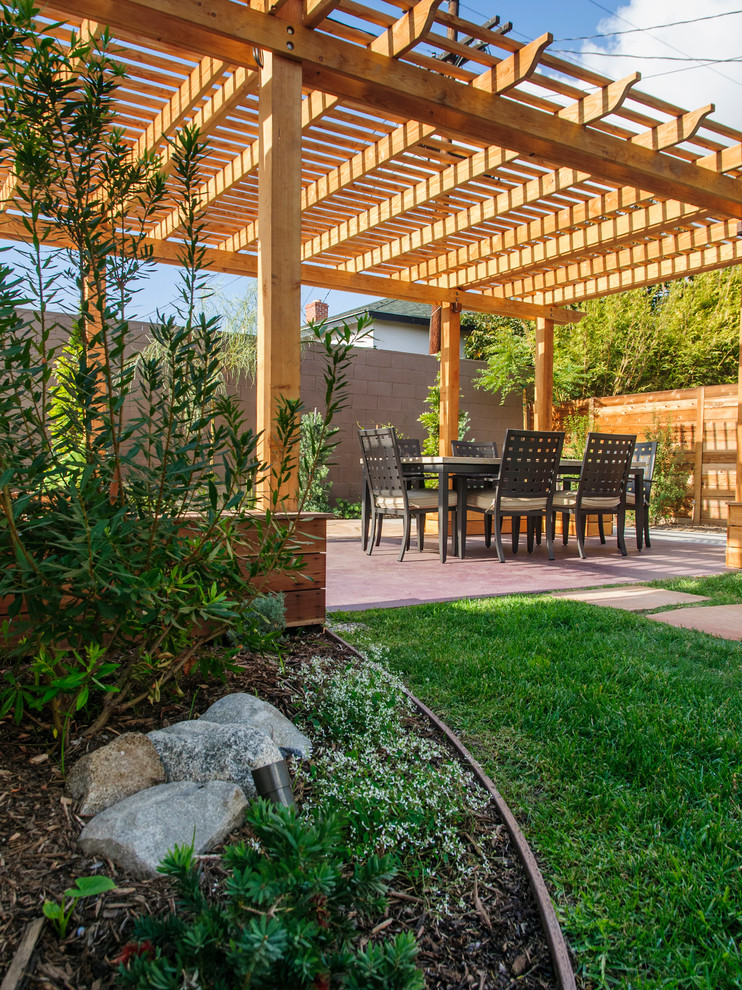 Inspiration for a mid-sized timeless backyard stone patio remodel in Los Angeles with a pergola