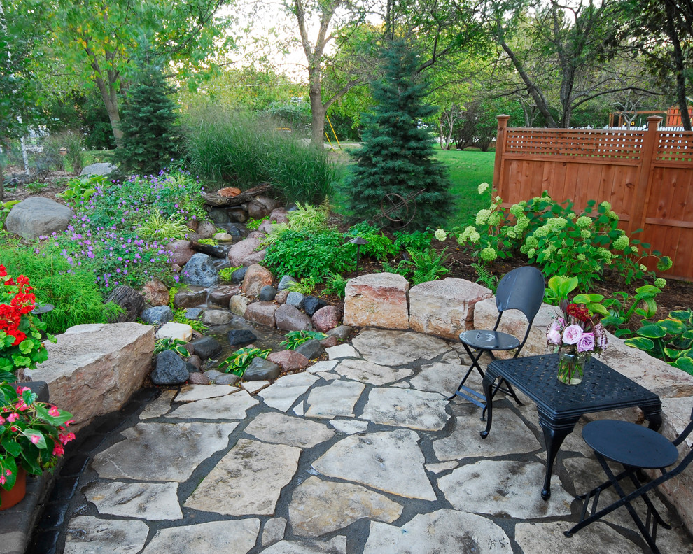 This is an example of a traditional patio in Milwaukee with a water feature.
