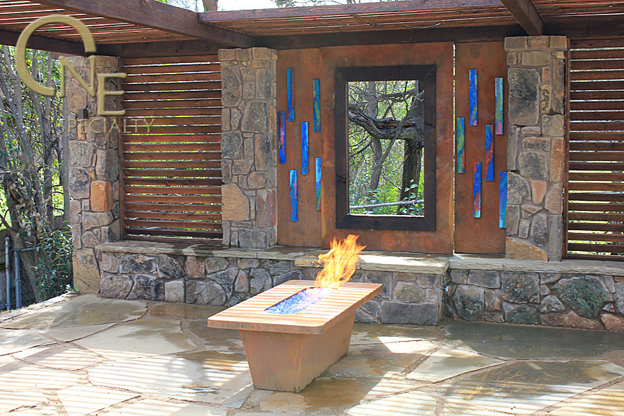 Cette image montre une terrasse arrière bohème de taille moyenne avec un foyer extérieur, des pavés en pierre naturelle et une pergola.