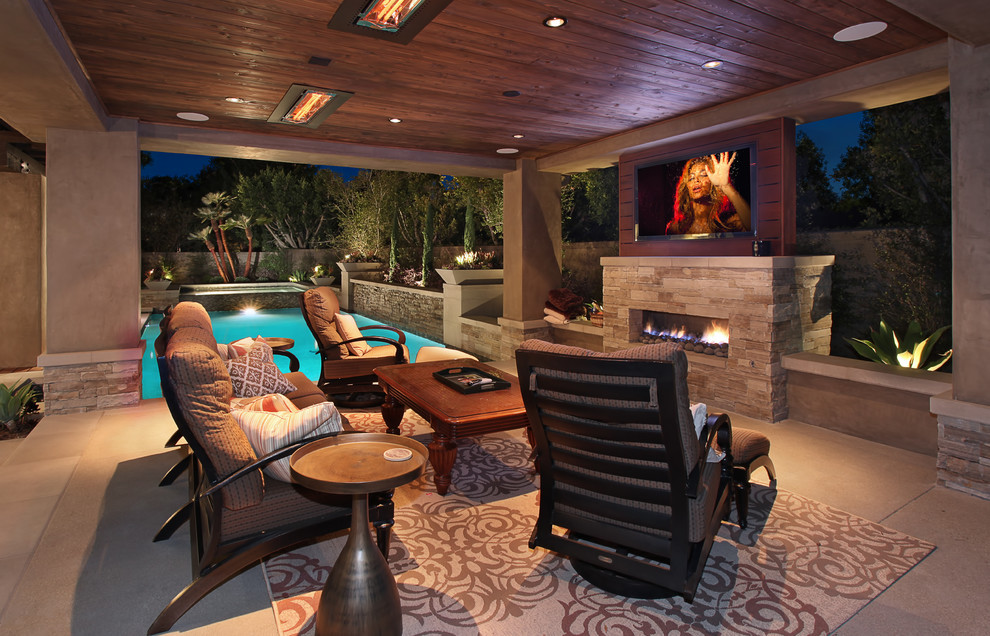Patio - large contemporary backyard concrete paver patio idea in Orange County with a fire pit and a roof extension