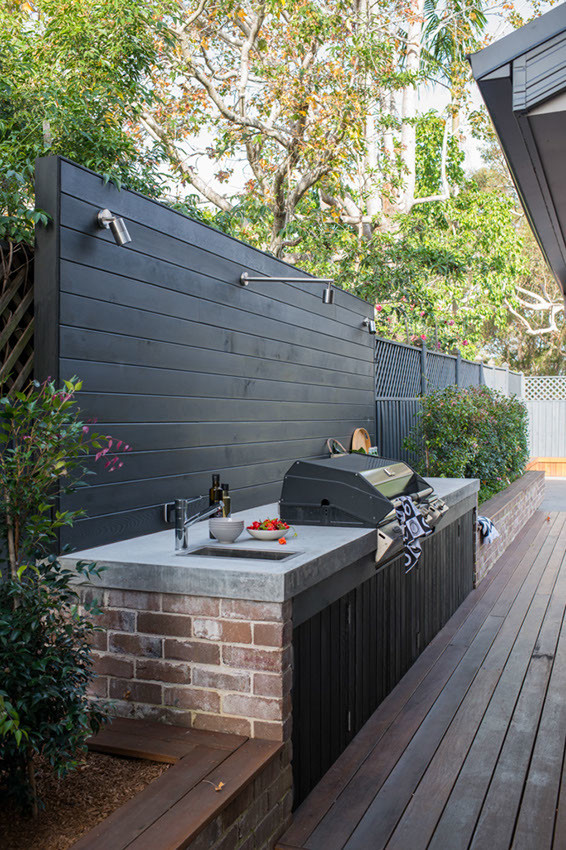 Large world-inspired back patio in Sydney with an outdoor kitchen, decking and no cover.