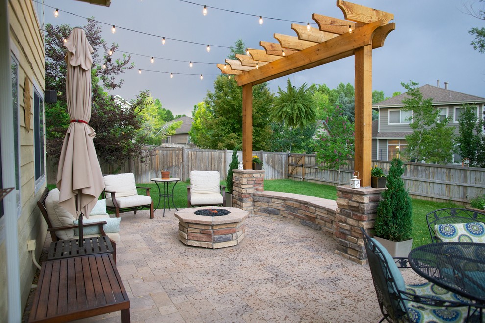 Ejemplo de patio clásico de tamaño medio en patio trasero con brasero, adoquines de ladrillo y pérgola