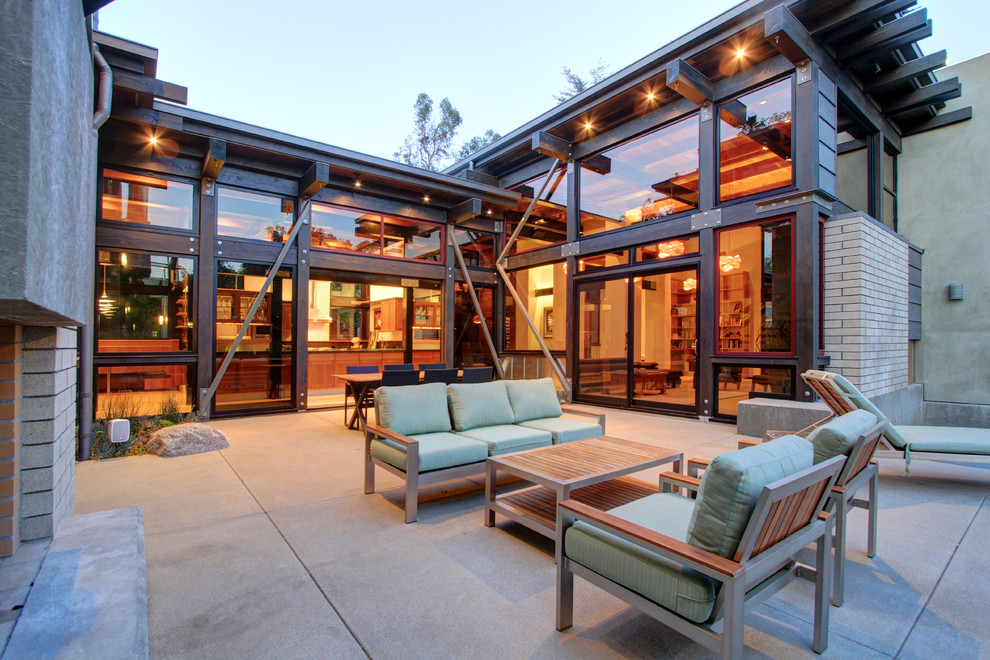 Inspiration for a large urban back patio in Los Angeles with a fire feature, concrete slabs and no cover.