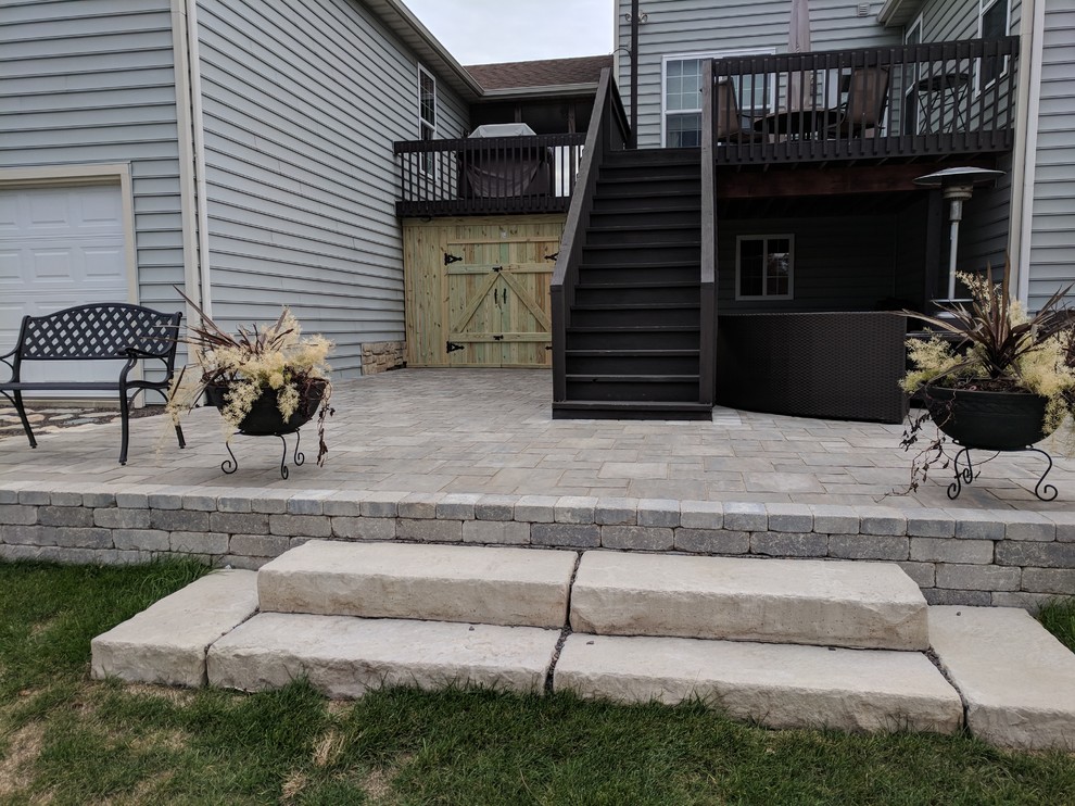 Foto di un patio o portico chic di medie dimensioni e dietro casa con un focolare, pavimentazioni in cemento e una pergola