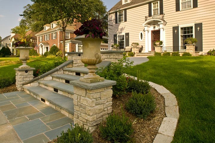 Example of a 1960s front yard stone patio design in Minneapolis