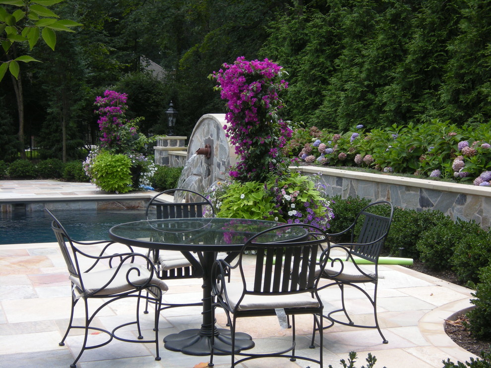 Inspiration for a medium sized traditional back patio in New York with a water feature and natural stone paving.