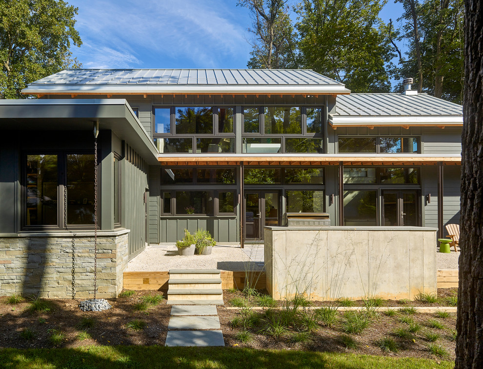 Cette photo montre une grande terrasse arrière tendance avec une cuisine d'été, du gravier et une extension de toiture.