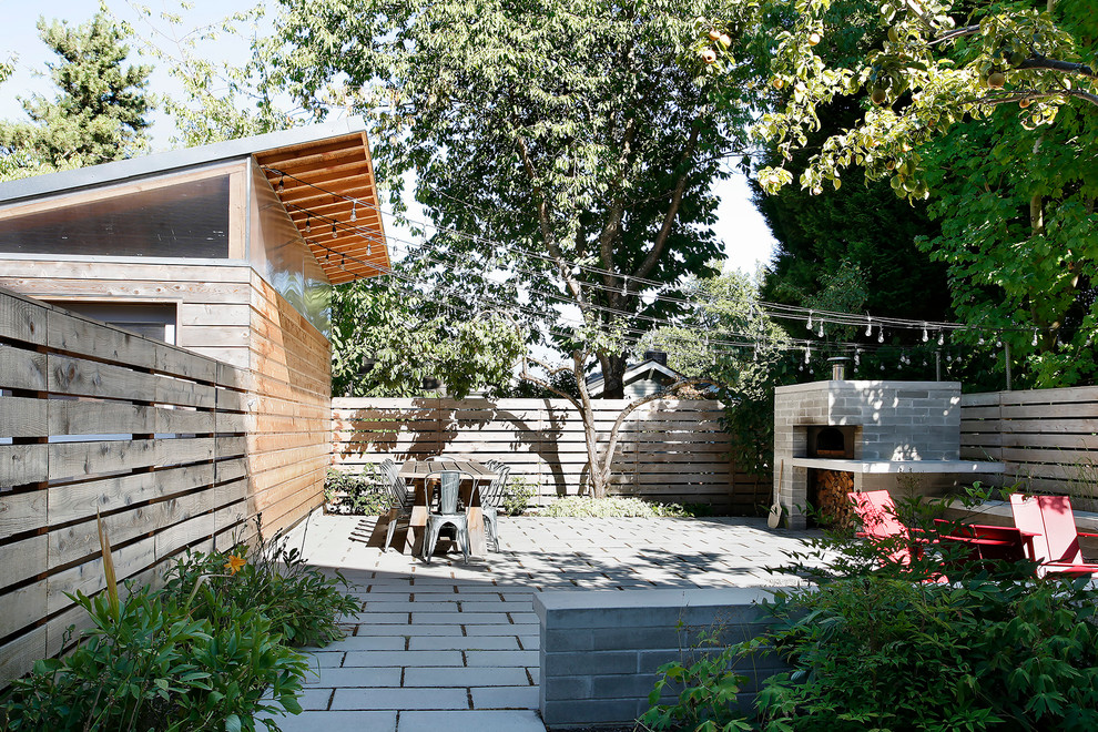 Medium sized contemporary back patio in Seattle with a fire feature and concrete paving.