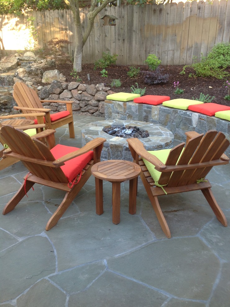 Inspiration for a mid-sized eclectic backyard stone patio remodel in San Francisco with a fire pit
