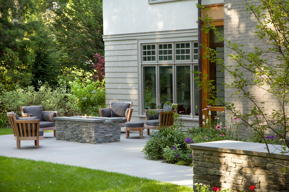 Esempio di un patio o portico american style di medie dimensioni e dietro casa con un focolare e pavimentazioni in pietra naturale