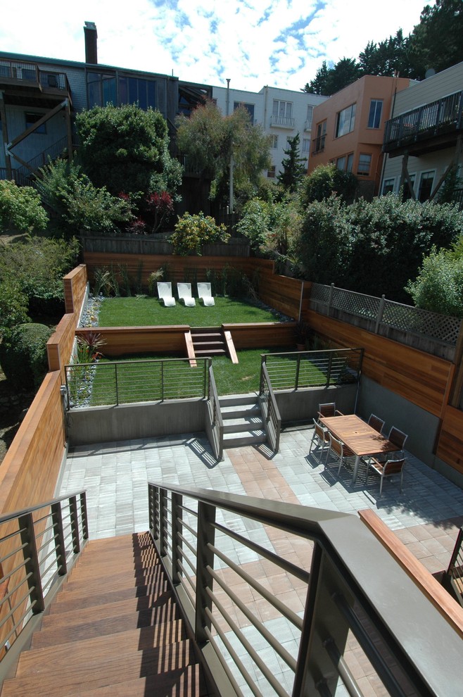 Стильный дизайн: двор на заднем дворе в современном стиле с мощением тротуарной плиткой - последний тренд