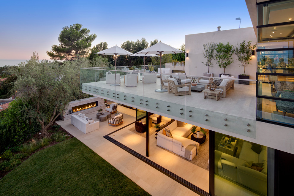 Huge trendy backyard tile patio photo in Los Angeles with a fire pit and a roof extension