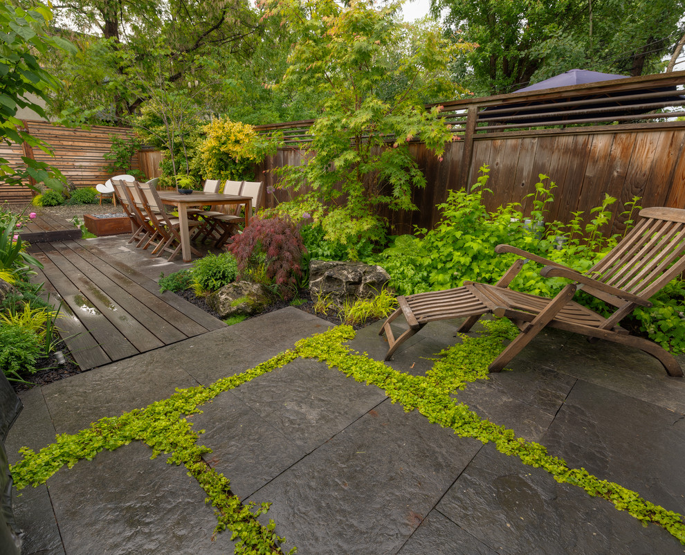 Réalisation d'une terrasse en bois arrière asiatique avec un foyer extérieur.