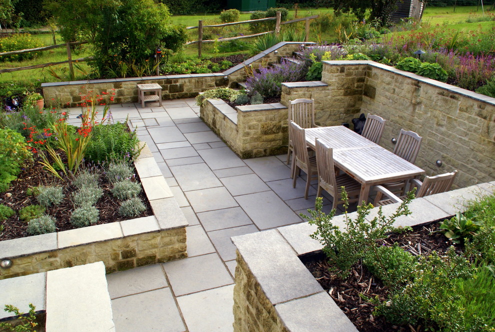 Immagine di un patio o portico country nel cortile laterale con pavimentazioni in pietra naturale
