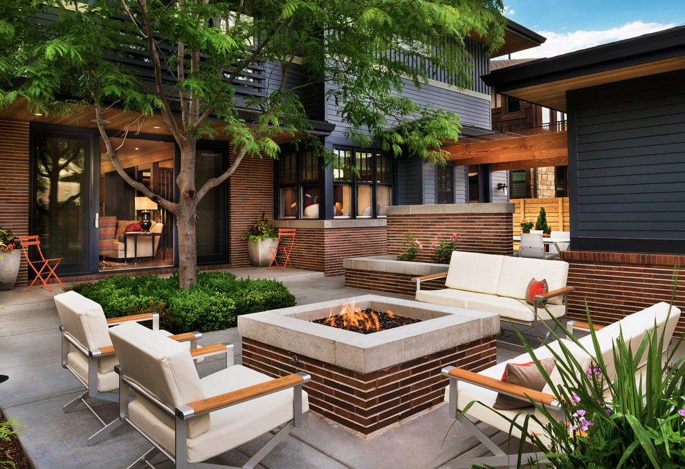 This is an example of a contemporary patio in Denver with a fire feature, concrete slabs and no cover.