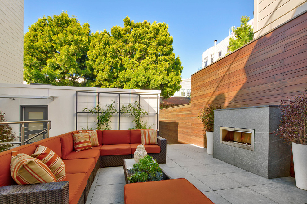 Example of a trendy backyard tile patio design in San Francisco with a fireplace