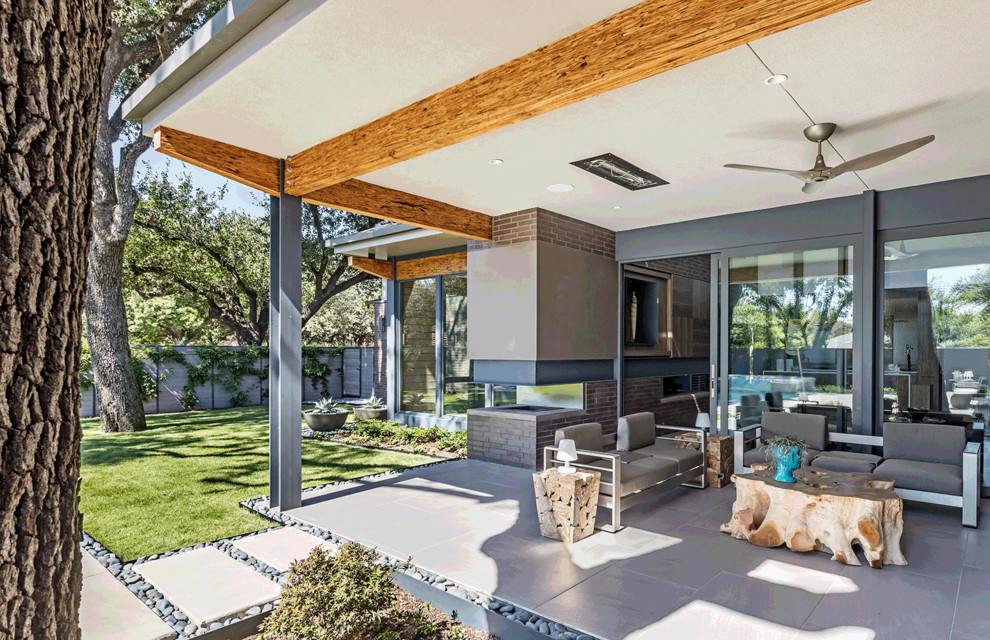 Cette photo montre une terrasse arrière tendance de taille moyenne avec une cuisine d'été, des pavés en béton et une extension de toiture.