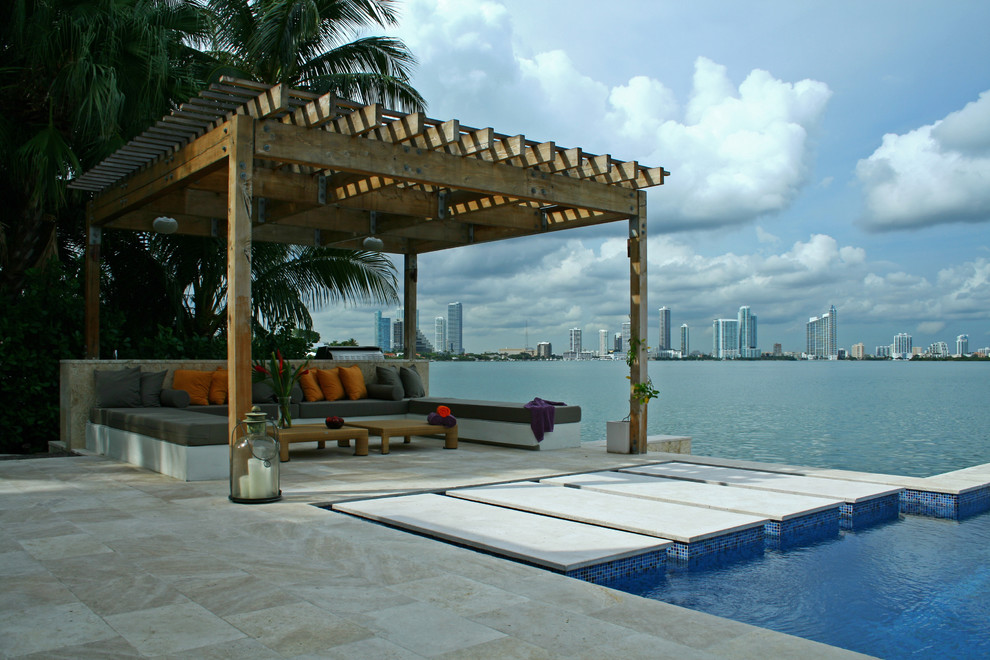 Immagine di un patio o portico minimalista di medie dimensioni e dietro casa con piastrelle e una pergola
