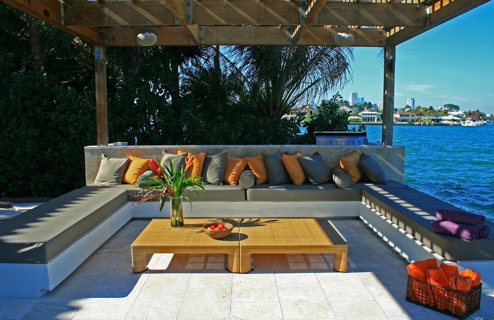 Example of a mid-sized minimalist backyard tile patio design in Miami with a pergola