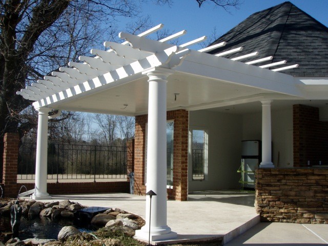 Imagen de patio moderno de tamaño medio en patio trasero con losas de hormigón y pérgola