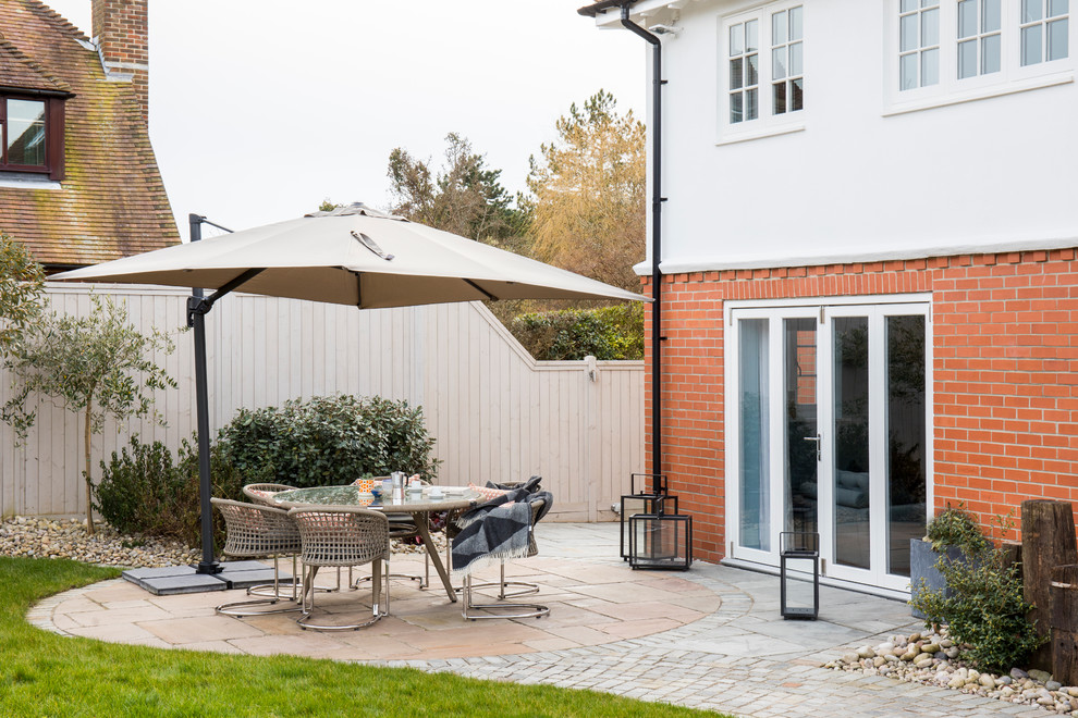 Foto de patio clásico renovado de tamaño medio sin cubierta en patio trasero con adoquines de piedra natural