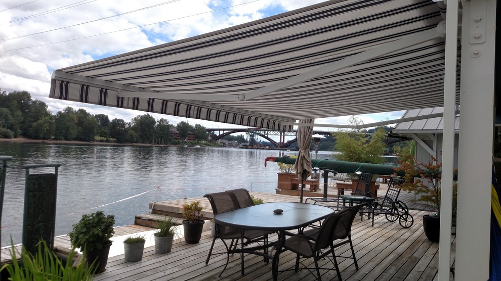 Example of a large beach style backyard patio design in Portland with an awning and decking