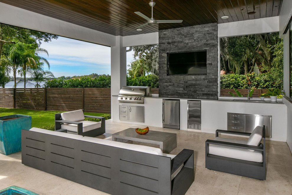 Cette photo montre une terrasse arrière moderne avec une cuisine d'été, des pavés en pierre naturelle et une extension de toiture.
