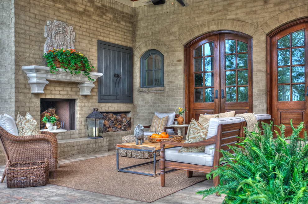 This is an example of a large traditional back patio in Little Rock with a fire feature, brick paving and a roof extension.