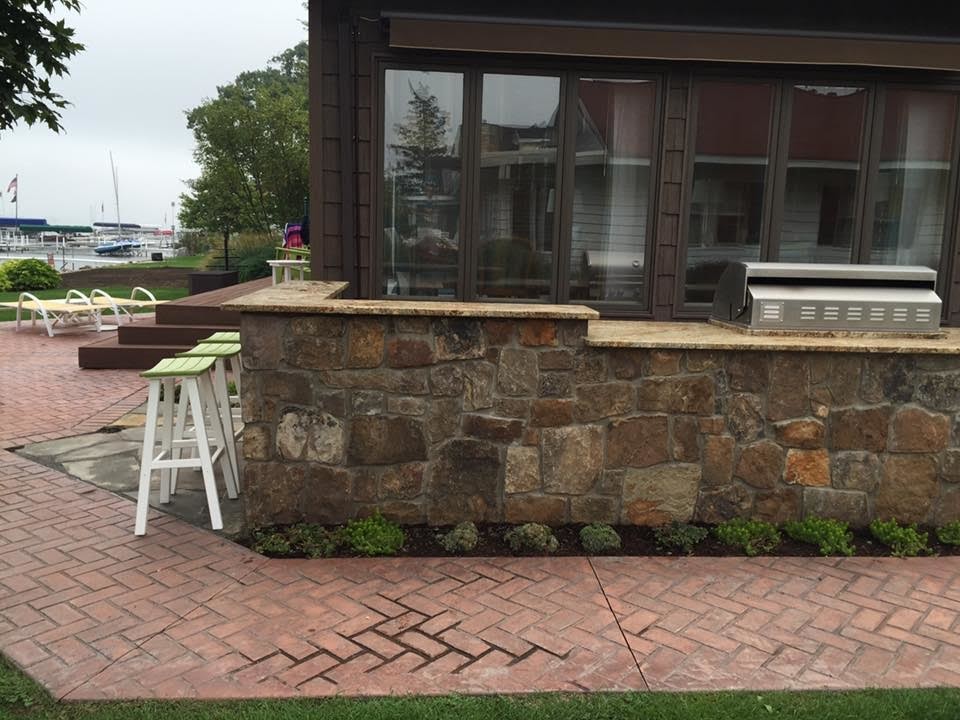 Exemple d'une grande terrasse arrière craftsman avec une cuisine d'été, des pavés en brique et aucune couverture.