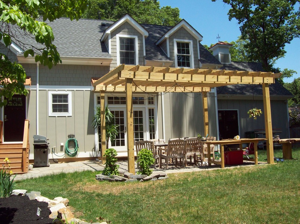 Esempio di un patio o portico country di medie dimensioni e dietro casa con pavimentazioni in pietra naturale e una pergola