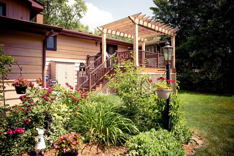 Cette image montre une terrasse en bois traditionnelle de taille moyenne avec une cour et une pergola.