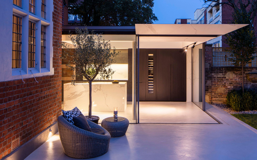 Design ideas for a medium sized modern back patio in London with concrete slabs and no cover.
