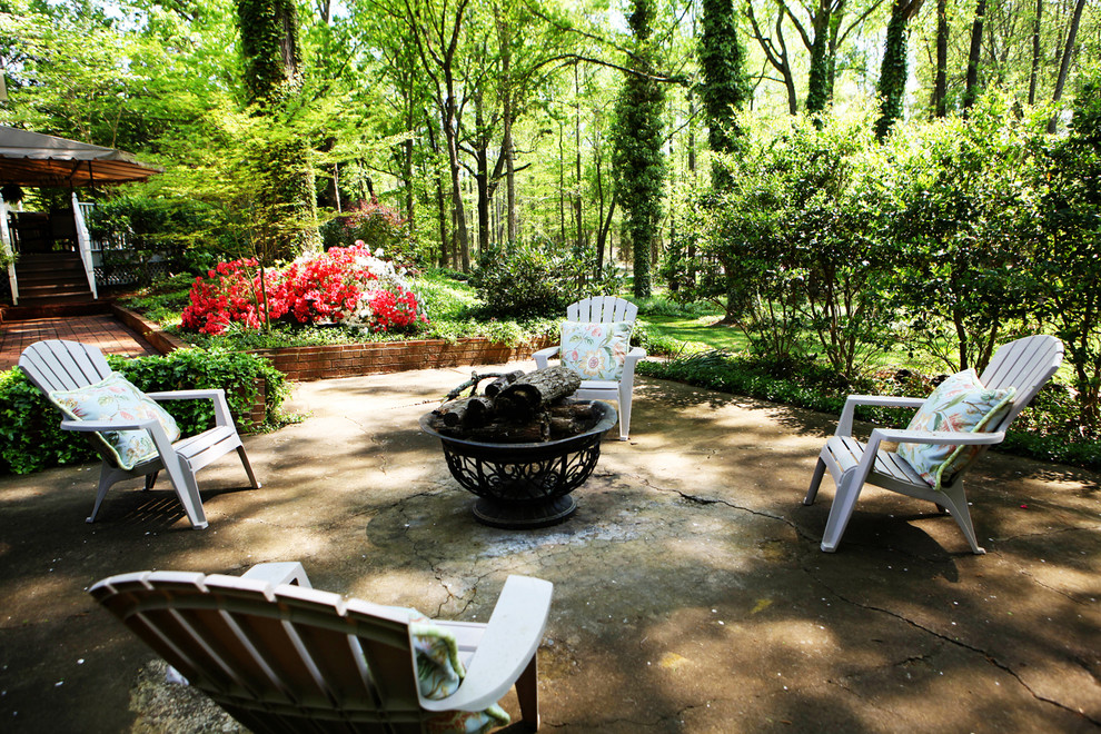 Example of a mid-sized farmhouse backyard concrete patio design in Charlotte with a fire pit