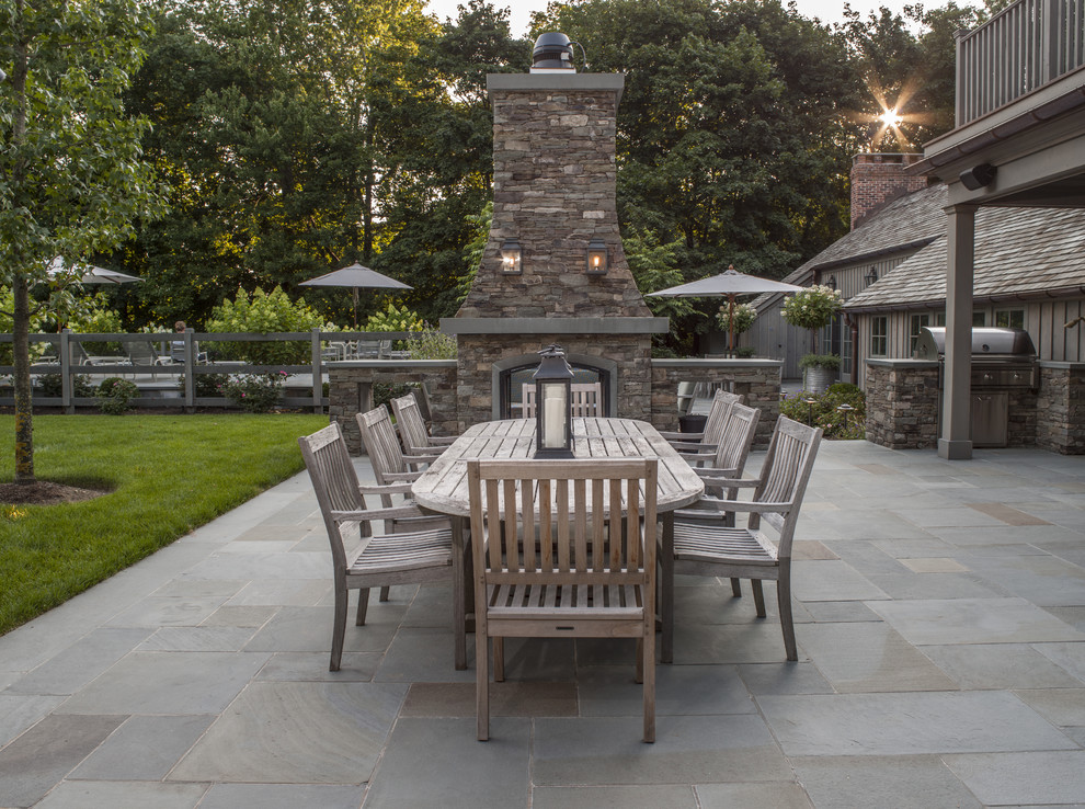 Photo of a medium sized country back patio in New York with natural stone paving and no cover.