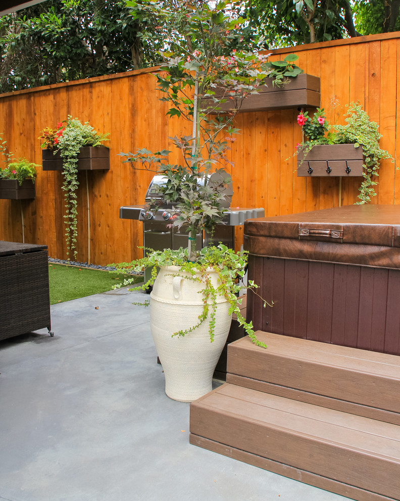 This is an example of a small eclectic back patio in Orange County with a living wall and concrete slabs.