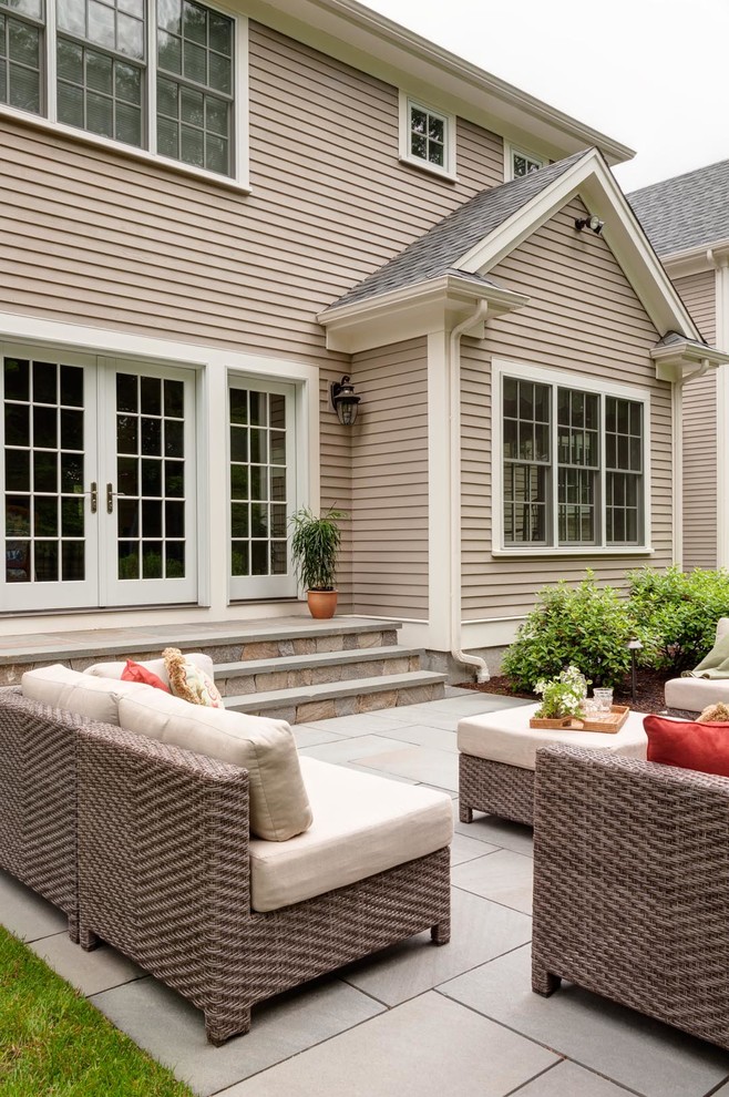 Foto di un patio o portico classico dietro casa con pavimentazioni in pietra naturale, nessuna copertura e scale