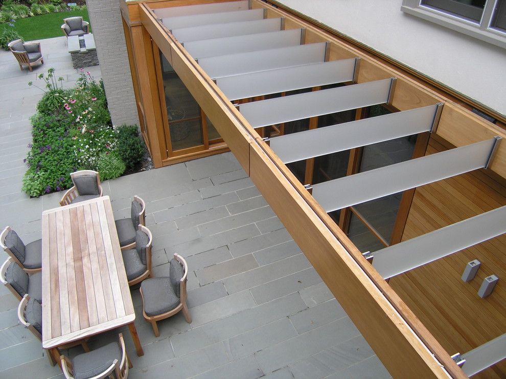 This is an example of a contemporary patio in Boston with a pergola.