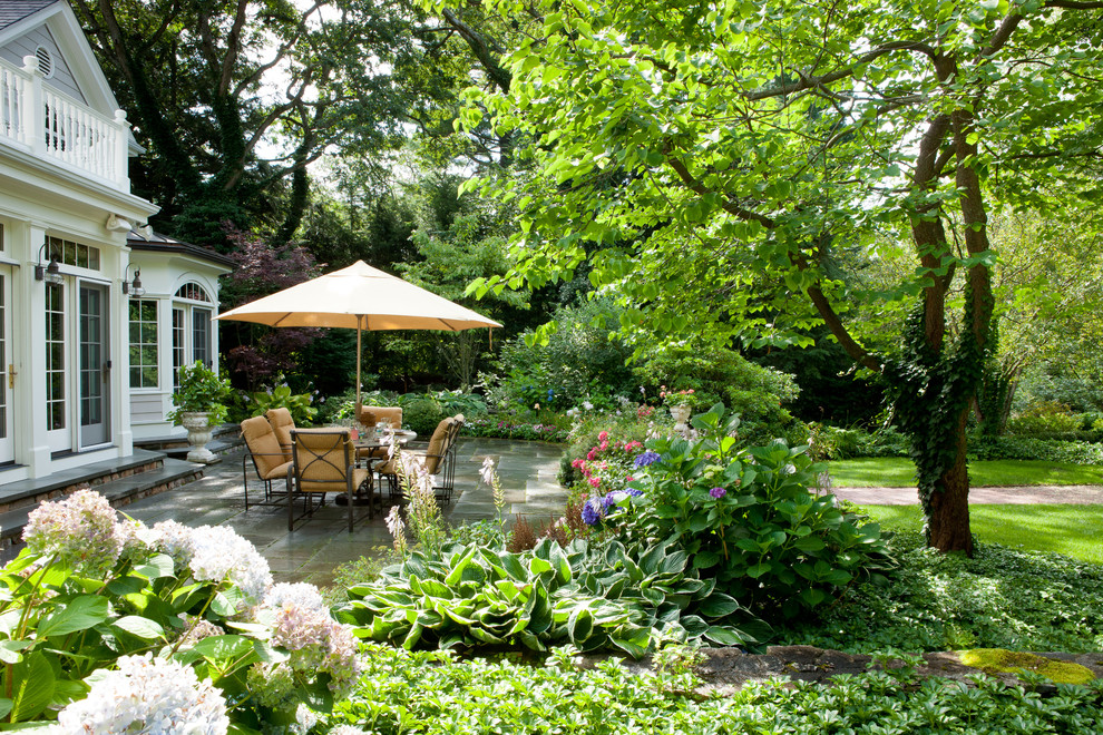 Diseño de patio clásico grande sin cubierta en patio trasero con adoquines de hormigón