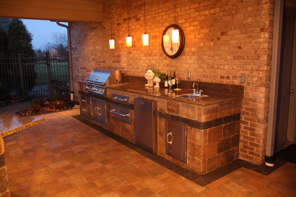 Mid-sized elegant backyard concrete paver patio kitchen photo in Other with a roof extension